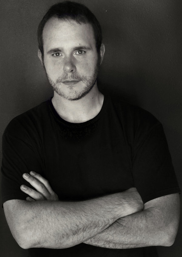 audiosalvage, a.k.a. Vic Dillahay, standing with arms crossed, in black and white