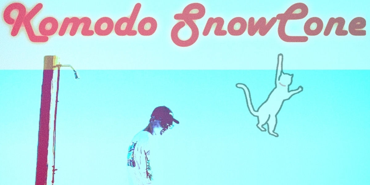 A clipart cat hangs from a Komodo SnowCone banner. A pole is at the left and the outline of the artist is centered.