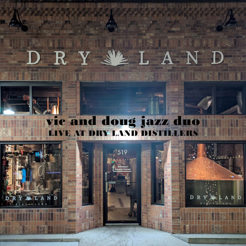 Dry Land cover. The front entrance of Dry Land Distillers at night.