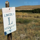 Lincoln Highway album cover. A faded sign for the Lincoln Highway attached to a fence post in a field near Fort Fred Steele in Wyoming.